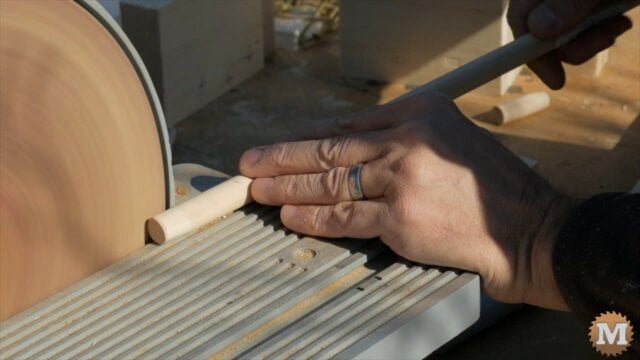 cutting wooden dowel on a saw