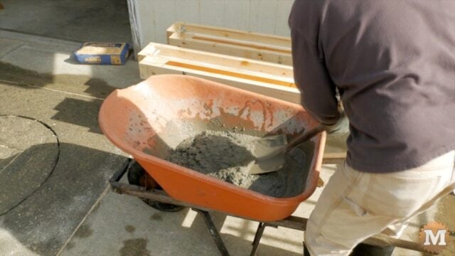 mixing concrete by hand with shovel and wheelbarrow