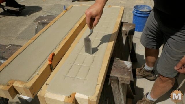 pushing the wire mesh into the form while the CSA mortar mix is still wet